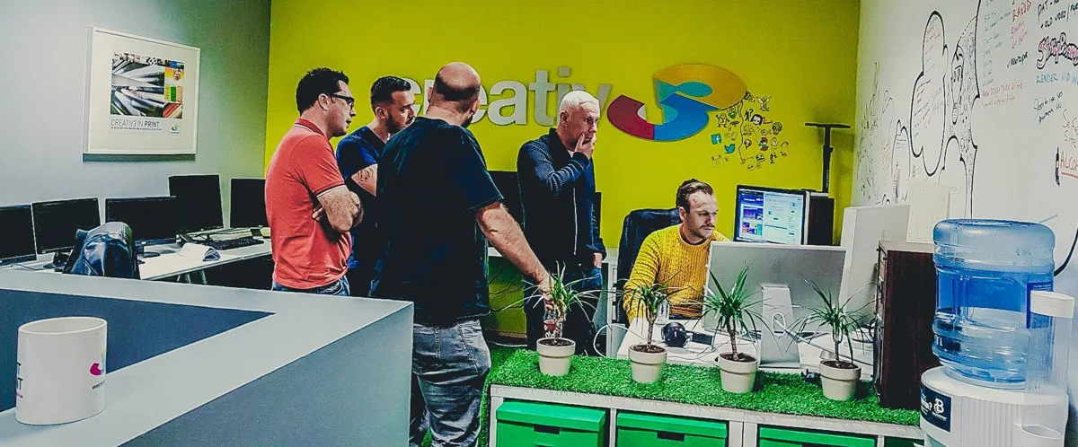 Creative 3 Media team reviewing work together in the studio
