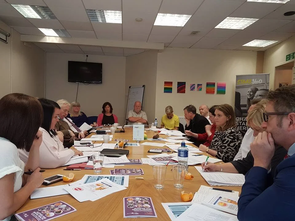 Stakeholders reviewing public health resources around a meeting table