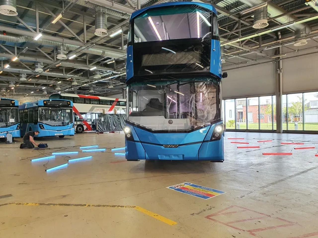 Blue buses inside a large production facility