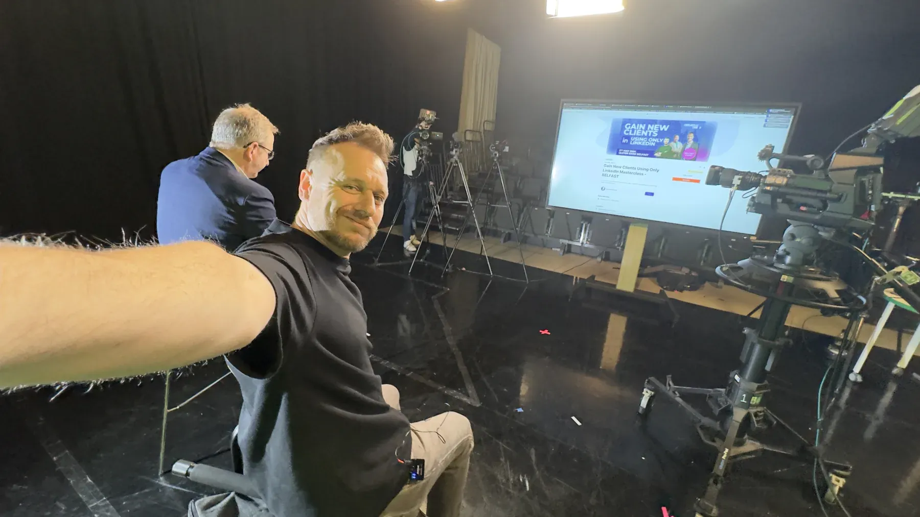 Crew reviewing a large video monitor on set