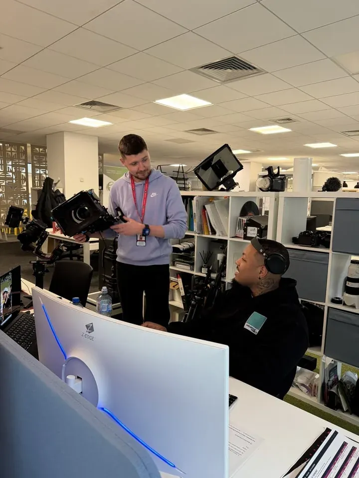 Team members collaborating across desks in the office