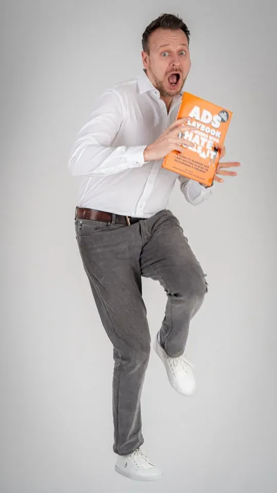 Playful jumping portrait holding the Ads Playbook