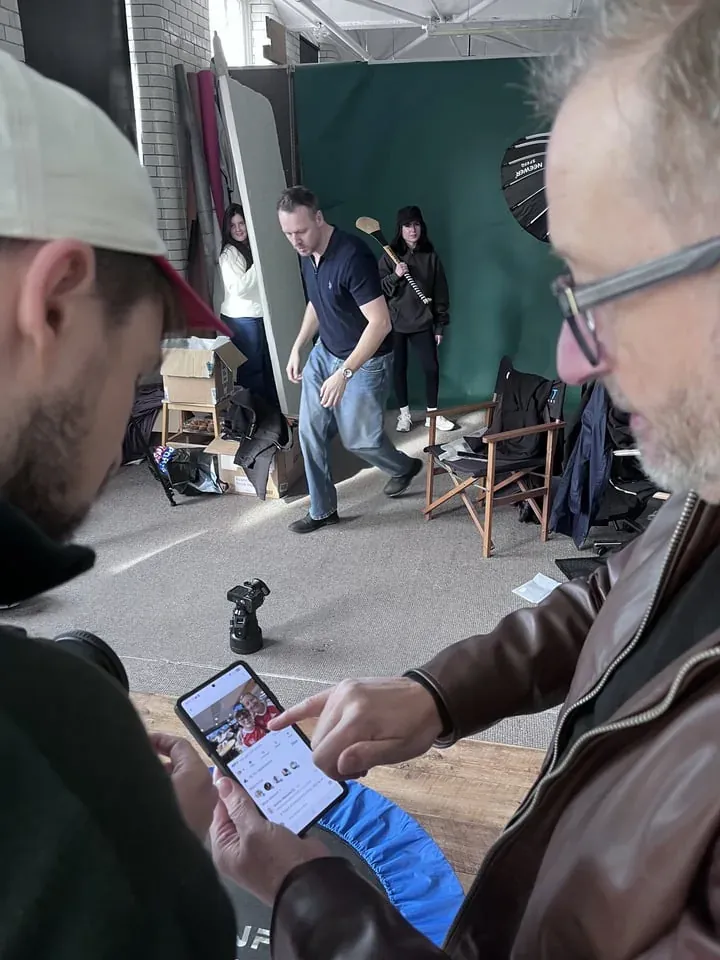 Production crew reviewing a tablet on set
